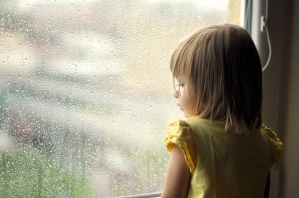Criança observando a chuva