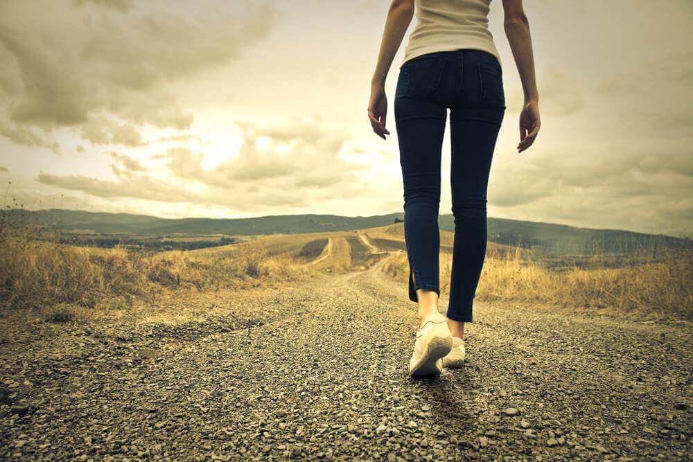 Mulher caminhando em estrada