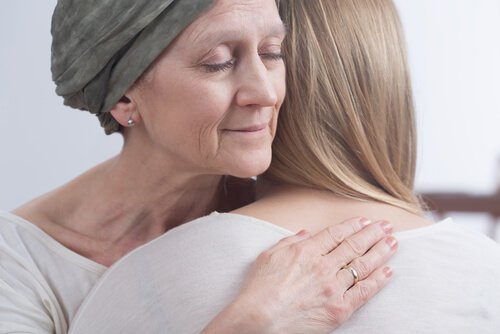 Mulher com câncer abraçando filha