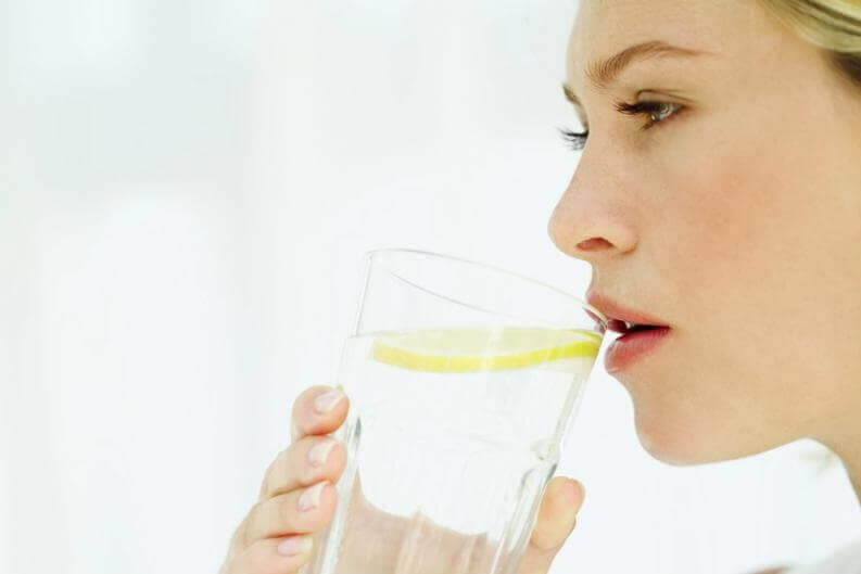 Mulher bebendo água com limão