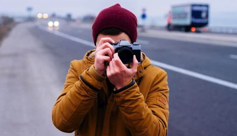 Homem tirando foto em estrada