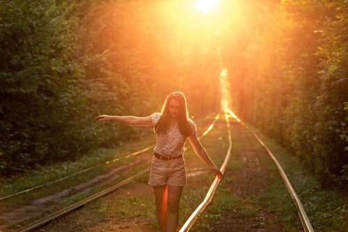 Mulher andando em trilho de trem