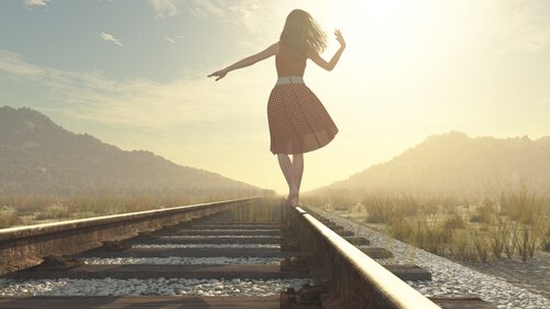 Mulher andando em trilho de trem