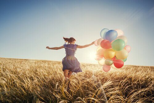 Mulher correndo com balões coloridos