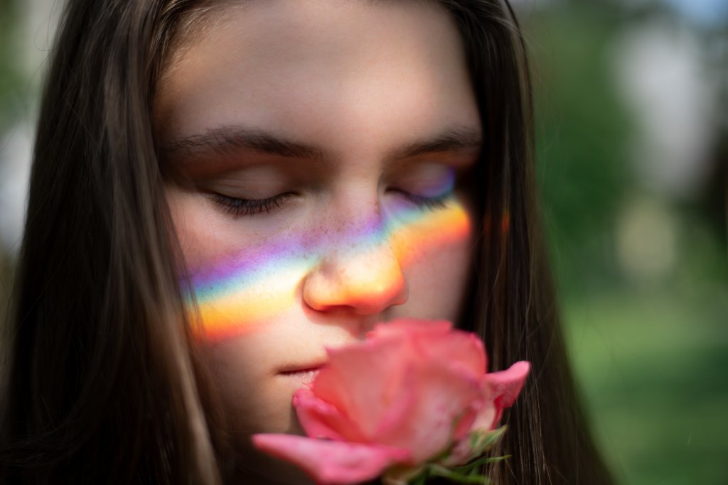 Jovem sentindo aroma de flor