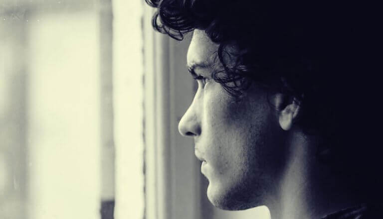 Jovem olhando pela janela