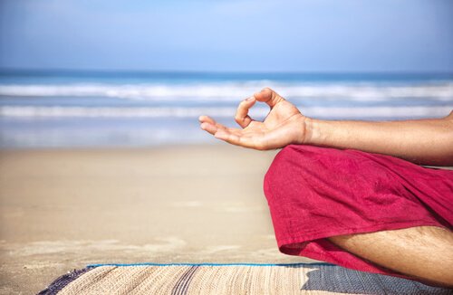 Pessoa meditando na praia