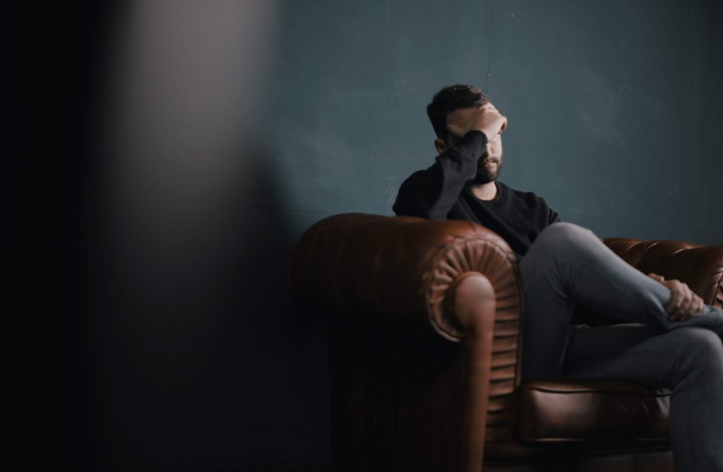 Homem em sala de espera de consultório terapêutico