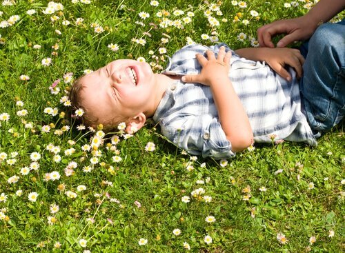 Criança rindo deitada na grama