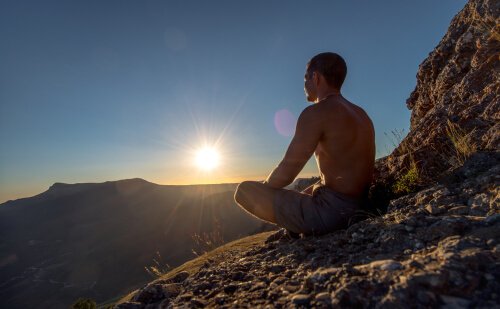 Homem meditando em montanha
