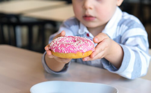 Criança comendo doce rico em açúcar