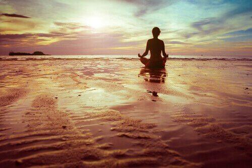 Mulher meditando na praia