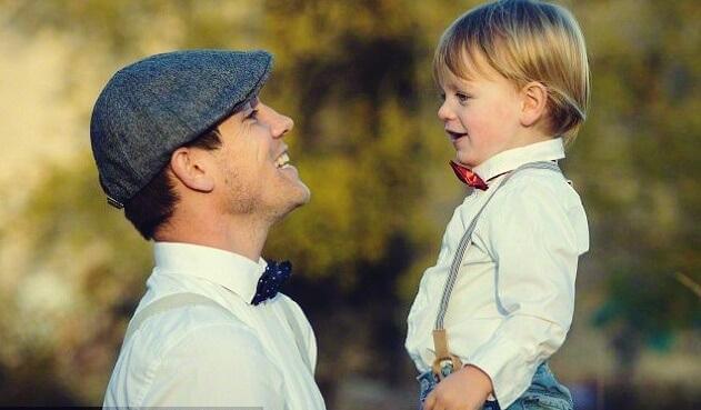 Pai sorrindo para o filho pequeno
