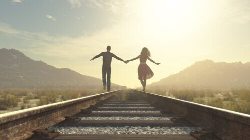 Casal andando no trilho do trem