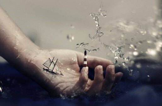 Mão com barco e farol