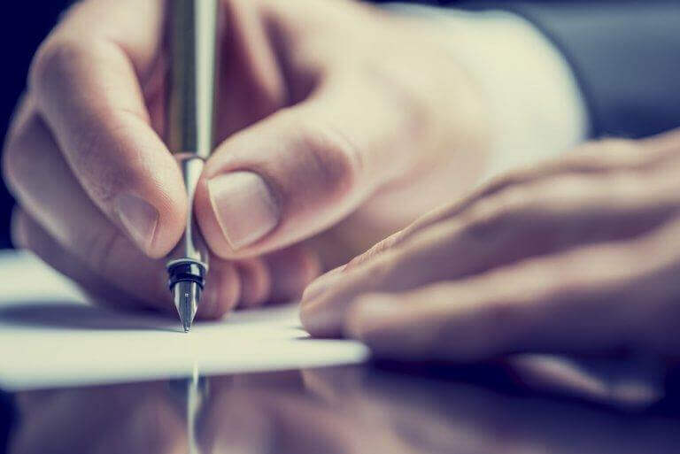 Mão escrevendo com caneta tinteira