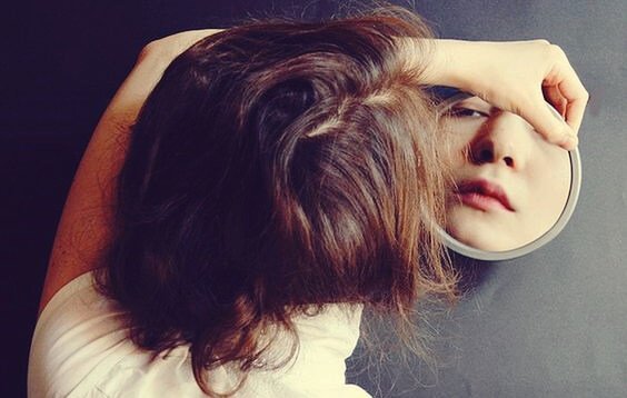 Mulher se olhando no espelho