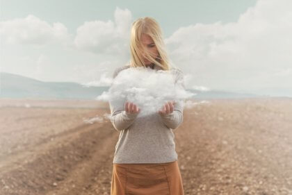 Mulher segurando uma nuvem em um deserto