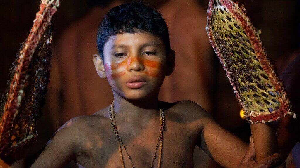 Criança indígena participando de ritual