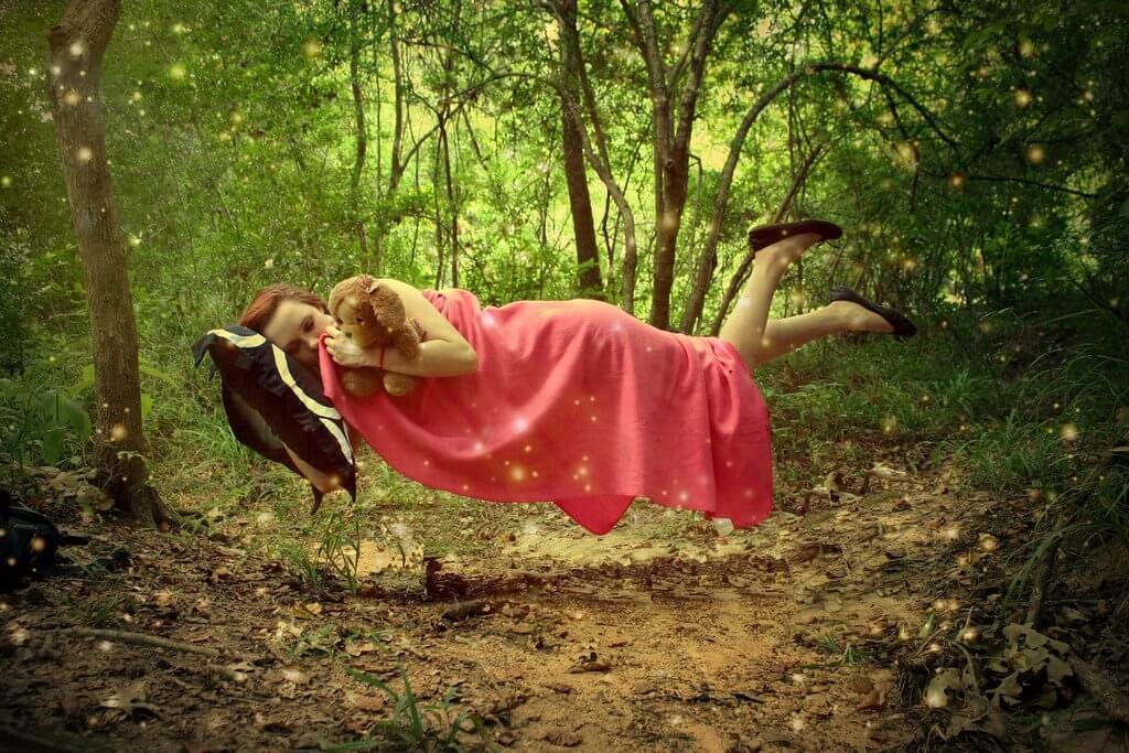 Mulher dormindo flutuando em floresta