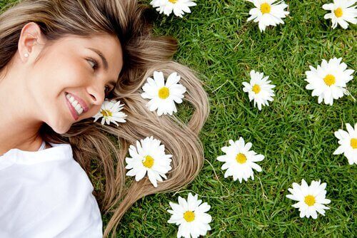Mulher deitada na grama com flores