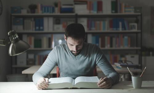 Homem estudando em biblioteca