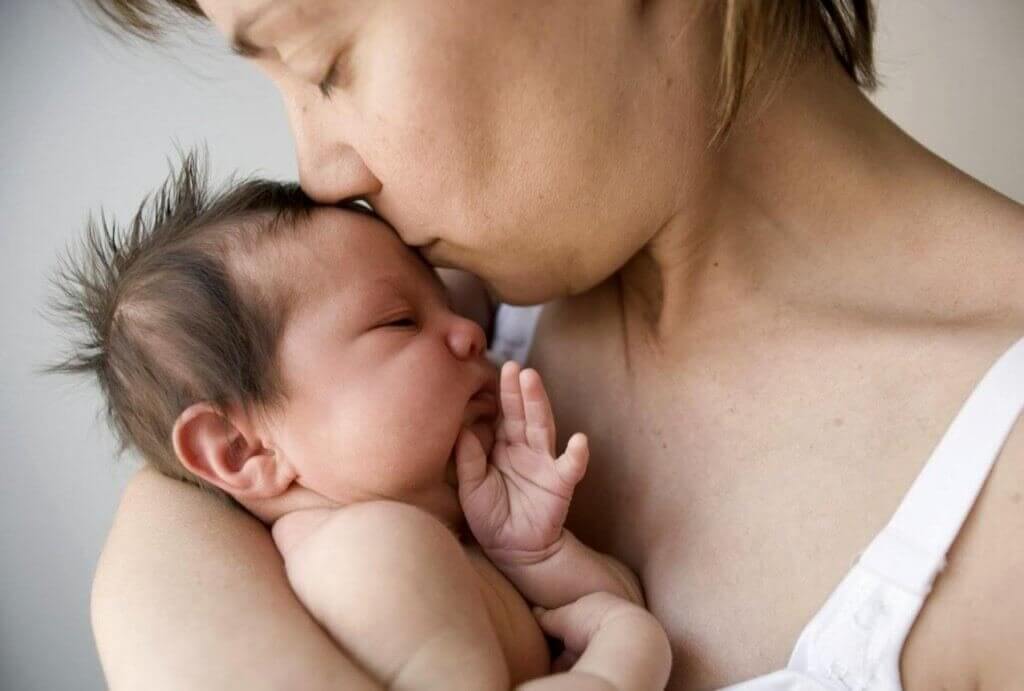 Mãe beijando seu bebê carinhosamente