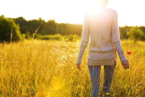 Mulher caminhando sob o sol