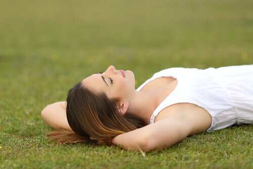Mulher deitada na grama relaxando