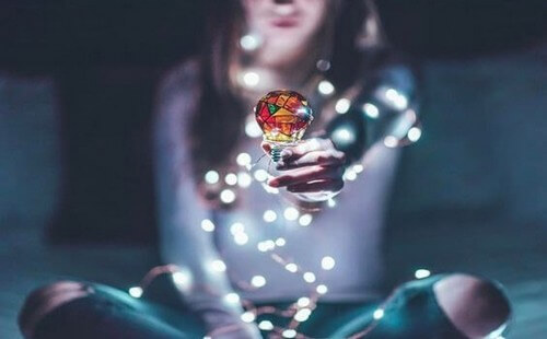 Mulher segurando lâmpada colorida