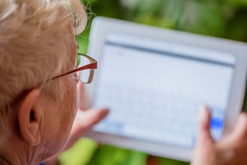 Idosa com tablet nas mãos