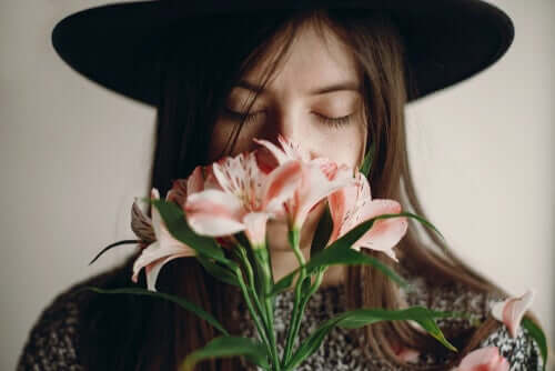 Mulher sentindo o aroma de flores