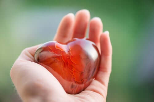 Mão segurando coração de vidro