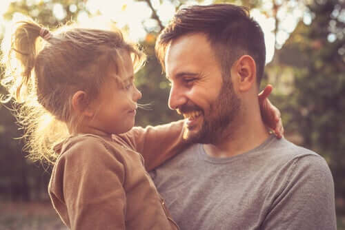 Pai sorrindo com filha no colo