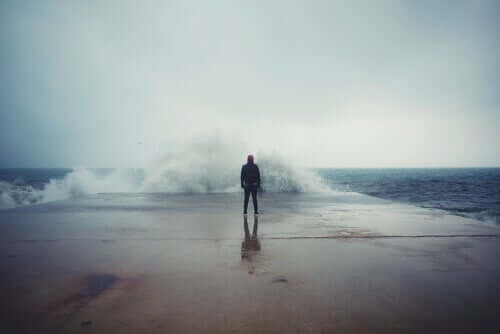 Homem diante de mar revolto