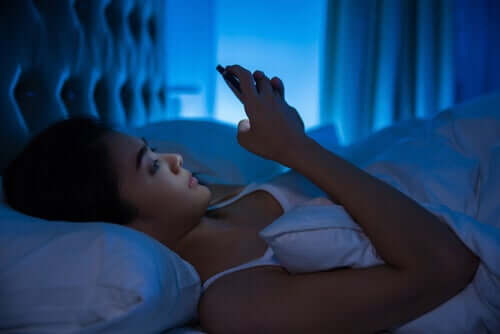 Mulher usando celular na cama