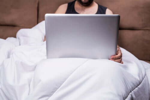 Homem vendo pornografia na cama