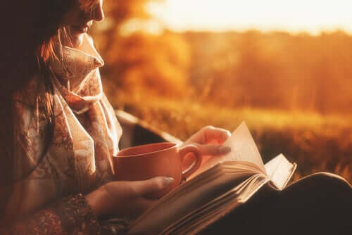 Mulher lendo um livro e tomando um café
