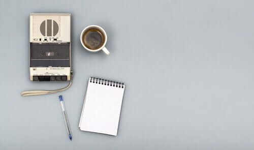 Gravador, café e caderno de anotações