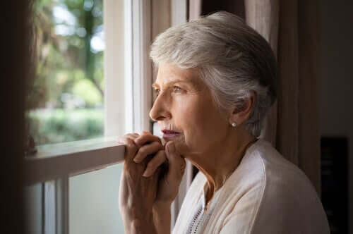 Mulher idosa olhando pela janela