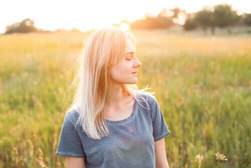 Mulher de olhos fechados no campo