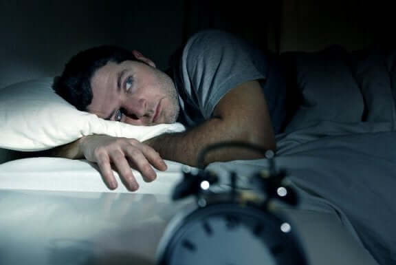 Homem com insônia sem conseguir dormir