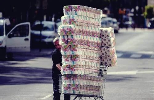 Pessoa comprando muitos pacotes de papel higiênico