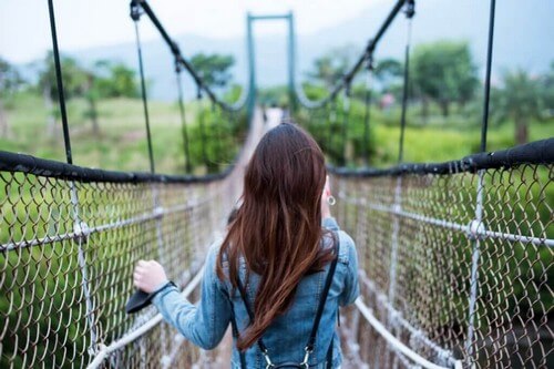 Mulher andando em ponte suspensa