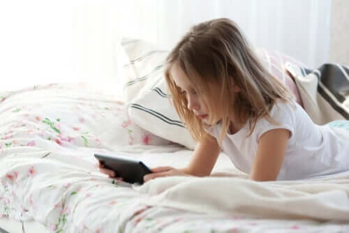 Menina com tablet na cama