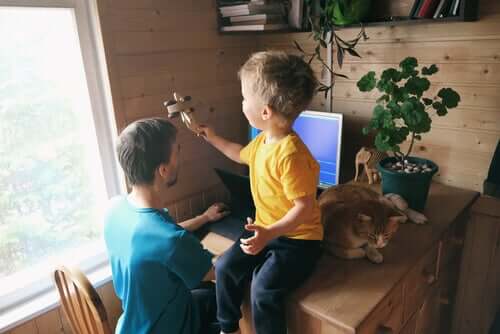 Pai trabalhando e filho brincando