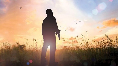 Homem em campo no pôr do sol