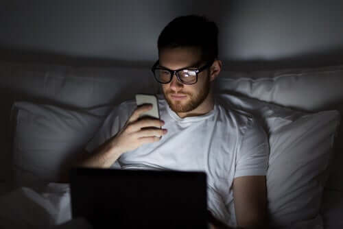 Homem olhando o celular a noite