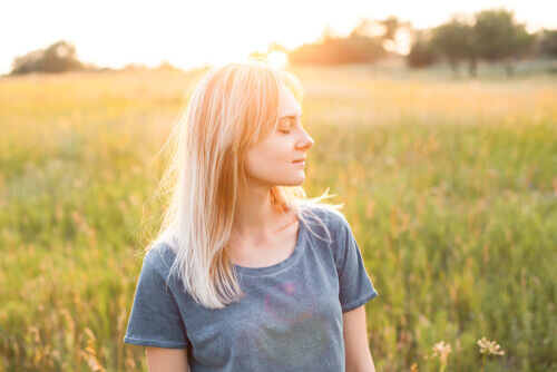 Mulher de olhos fechados no campo