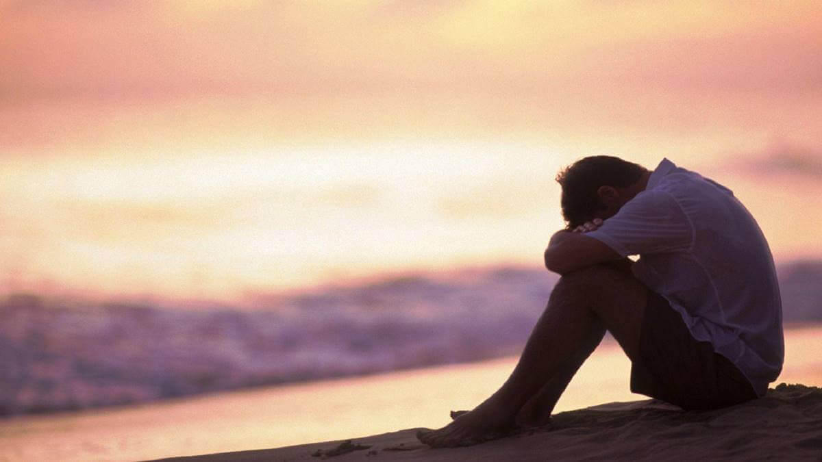 Homem triste na praia